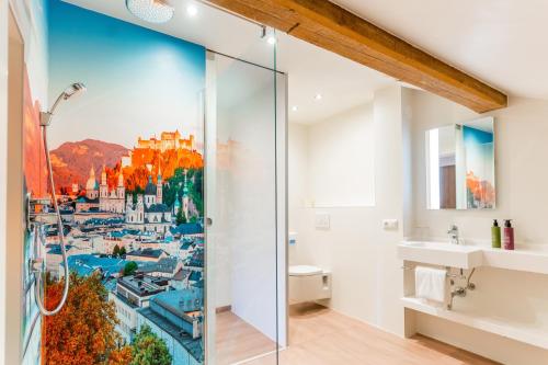 a bathroom with a shower with a city painting on the wall at Hotel Rosenvilla in Salzburg