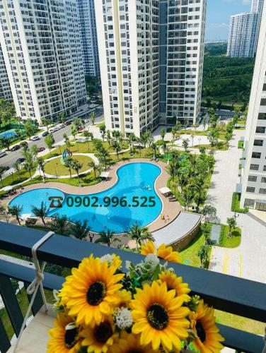 a view of a resort with a pool and flowers on a balcony at Homestay Sài Gòn-Vinhomes Grand Park Quận 9-Plus 2PN in Long Bình