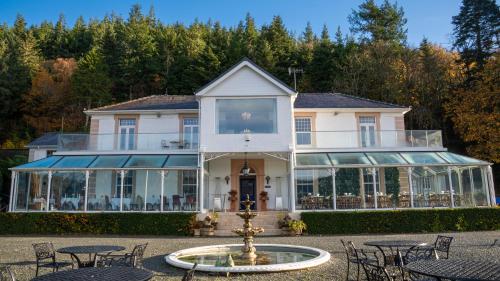 a large white house with a fountain in front of it at Plas Maenan in Conwy