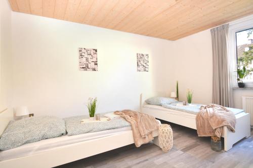 ein weißes Schlafzimmer mit 2 Betten und einem Fenster in der Unterkunft CO05-HI Apartment in Coburg in Coburg