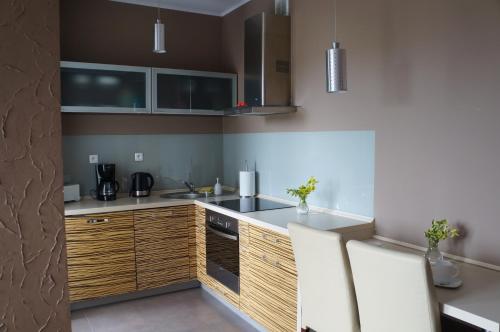 a kitchen with wooden cabinets and a counter top at Zacisze Leśne in Świnoujście