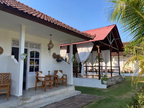 a house with a porch and a table and chairs at Rebels Point in Jimbaran