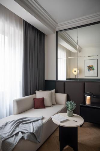 a living room with a couch and a table at Almanac X Alcron Prague in Prague