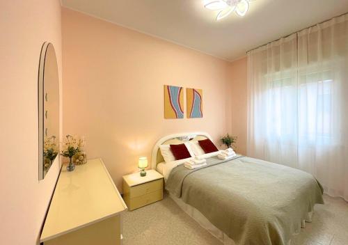 佩斯基耶拉德爾加爾達的住宿－Appartamento 2, Villa Magnolia, 64mq, Lago di Garda，一间卧室配有一张床、一个梳妆台和一扇窗户。