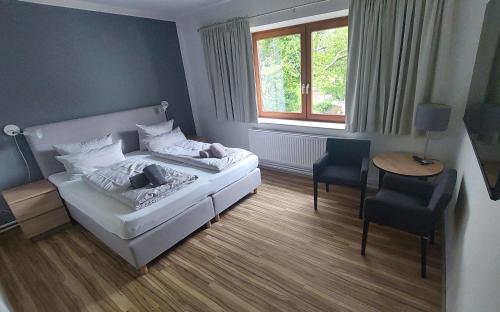 a bedroom with a bed and a table and a chair at Ording Beach Hotel in Sankt Peter-Ording