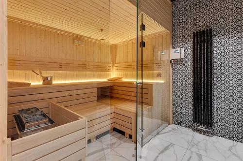 a sauna with a glass shower in a room at Downtown Apartments Riverside Nadmotławie Estate - Gym & Sauna in Gdańsk