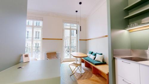 Il comprend une cuisine et un salon avec une table. dans l'établissement JOIVY Premium flats in the heart of the 9th arr, near Moulin Rouge, à Paris