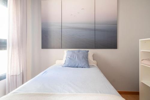 a bedroom with a bed with a painting on the wall at Mi pequeña bahia in Alicante