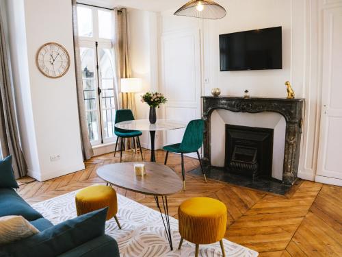 a living room with a fireplace and a tv at Superbe T2 avec vue sur cour - Rouen centre in Rouen