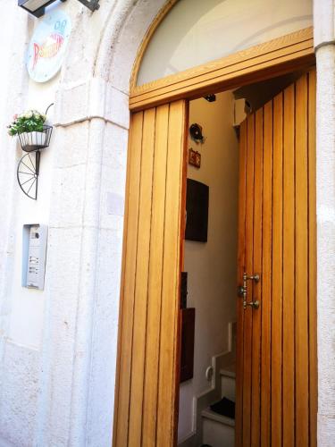 an open wooden door in a building with a plant at PESCIOLINO B&B in Mola di Bari