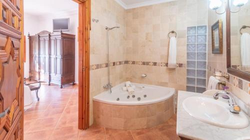 uma casa de banho com uma banheira e um lavatório em Villa el Señorío Alameda by Ruralidays em Antequera