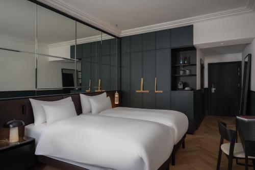 a bedroom with a large white bed and a chair at Almanac X Alcron Prague in Prague
