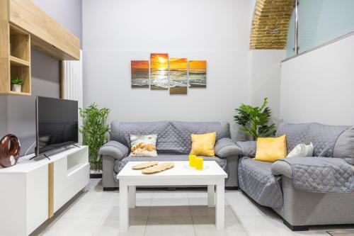 - un salon avec un canapé et une télévision dans l'établissement Apartamento Barrocal by Cadiz Time, à Cadix