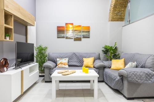 ein Wohnzimmer mit Couch und Fernseher in der Unterkunft Apartamento Barrocal by Cadiz Time in Cádiz
