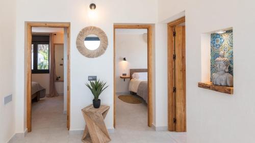 einen Flur mit einem Schlafzimmer mit einem Bett und einem Spiegel in der Unterkunft Villa Isabella Cómpeta by Ruralidays in Cómpeta