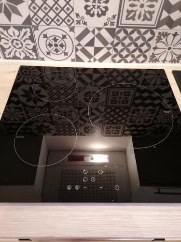 une télévision dans une pièce avec un mur à motifs dans l'établissement JOLIE LOGEMENT AU COEUR DU PAYS BASQUE, à Chéraute