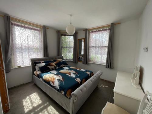 um quarto com uma cama num quarto com janelas em SOUTH COAST ROOM WITH PARKING SPACE NEAR THE BEACh em Poole