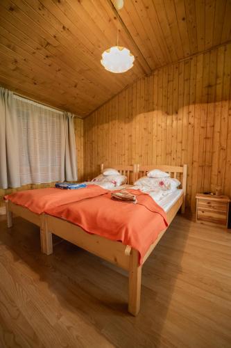 a bedroom with a bed in a wooden room at Biotour Camping & Restaurant in Ghimeş