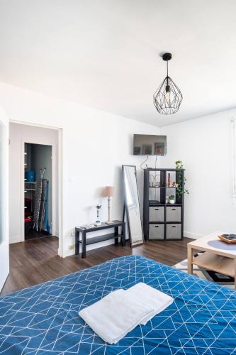 - une chambre avec un lit et une serviette dans l'établissement Magnifique Apt entièrement équipé proche des 24h du Mans, au Mans