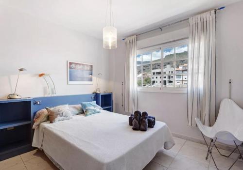 una camera con un letto e una sedia e una finestra di Caletillas Beach Apartment a Santa Cruz de Tenerife