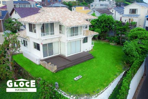 a large white house on a green lawn at GLOCE 葉山 Ocean View House 都心から1時間 湘南の絶景を独り占めペットok 出張BBQ有り in Yokosuka