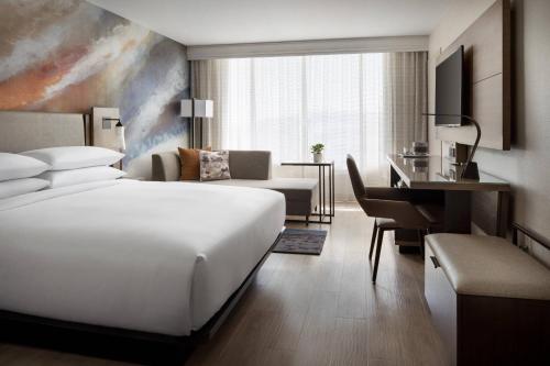 a hotel room with a white bed and a desk at Torrance Marriott Redondo Beach in Torrance