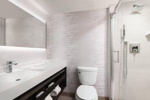 a white bathroom with a toilet and a shower at Torrance Marriott Redondo Beach in Torrance