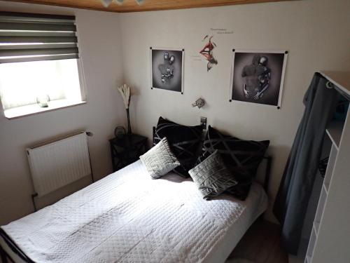 una camera da letto con letto, lenzuola e cuscini bianchi di Ferienwohnung Nayla im Frankenwald a Naila