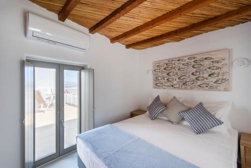 a bedroom with a bed and a large window at Rina Houses in Kampos Paros