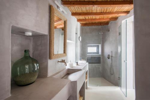 a bathroom with a large vase sitting next to a sink at Rina Houses in Kampos Paros