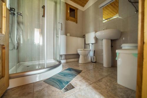 a bathroom with a tub and a toilet and a sink at Biotour Camping & Restaurant in Ghimeş