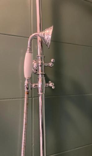 - un pommeau de douche dans la salle de bains à côté d'un miroir dans l'établissement Les Loges du Théâtre Monsigny, Centre-ville, à Boulogne-sur-Mer