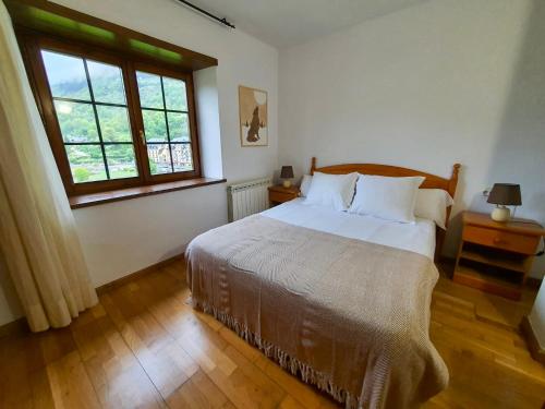 um quarto com uma cama grande e uma janela em VIelha V em Vielha