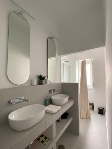 a bathroom with two sinks and two mirrors at CasaWolhão LIBERDADE maison de pêcheur avec toit-terrasse in Olhão