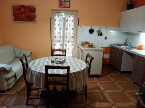 eine Küche mit einem Tisch und Stühlen sowie eine Küche mit einem Waschbecken in der Unterkunft ALLOGGIO TURISTICO LA MIMOSA in Magliano Sabina