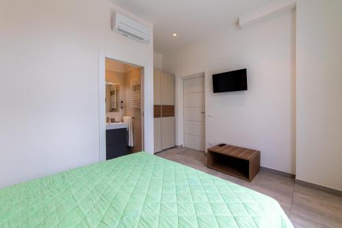 a bedroom with a green bed and a television at Villa Gina Case Vacanze in Roseto degli Abruzzi