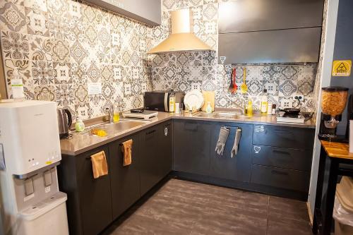 a small kitchen with blue cabinets and a refrigerator at Hostel Mihojae Busan in Busan