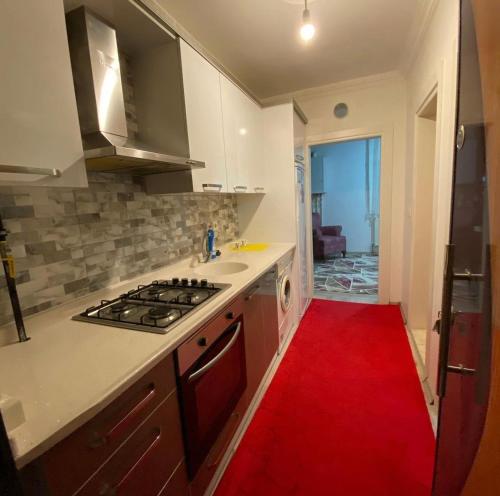 a kitchen with a stove and a red rug at Atakum Körfez Yat Limanı,Marina 20 Metre,Denize kolay ulaşım,Merkezi in Atakum