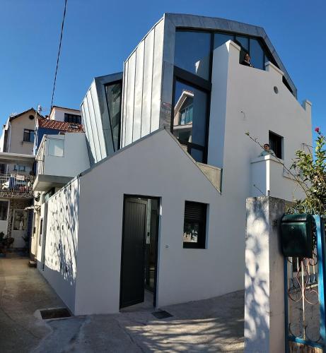 a white building with a black door at Apartamento Bruño julio y agosto min 7n in Cangas de Morrazo