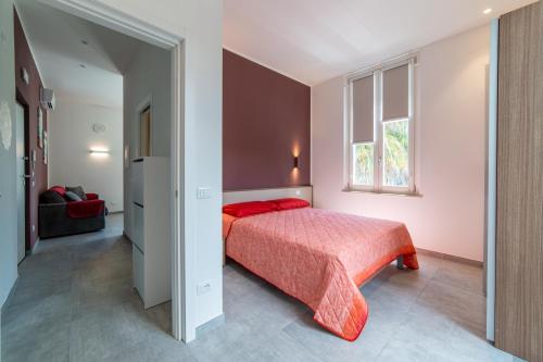 a bedroom with a red bed and a window at Villa Gina Case Vacanze in Roseto degli Abruzzi