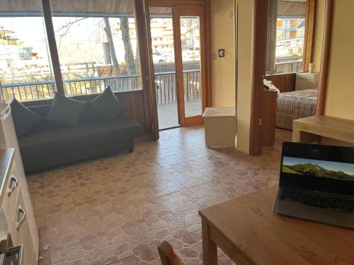 een woonkamer met een bank en een laptop op een tafel bij TERMINILLO - I Fiori del Terminillo - Tre Faggi in Terminillo