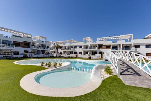 an apartment complex with a swimming pool and a bridge at 49 Laguna Beach in Torrevieja
