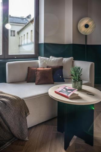a living room with a couch and a table at Almanac X Alcron Prague in Prague
