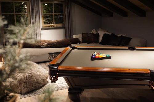 a living room with a pool table and a couch at Chalet S - 5 Sterne Luxus Ferienhaus direkt am Eibsee und Zugspitze in Grainau