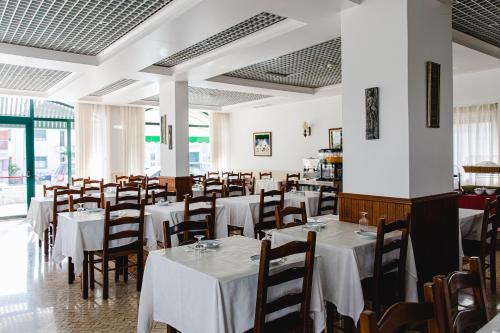 una sala da pranzo con tavoli e sedie bianchi di Hotel Santo António de Fátima a Fátima