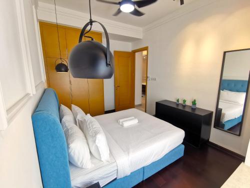 a bedroom with a bed and a blue couch at R&F PRINCESS COVE at ANJU in Johor Bahru