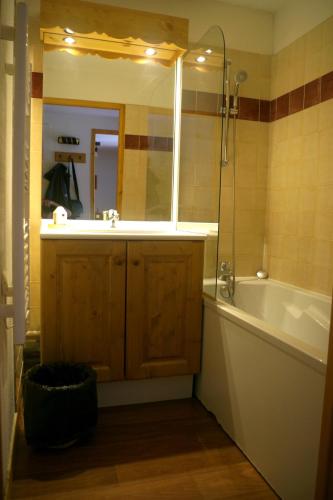 a bathroom with a tub and a sink and a mirror at Spacieux et Fonctionnel dans Ecrin des Neiges in Vars