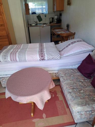 2 Betten in einem Zimmer mit einem Tisch und einer Küche in der Unterkunft Haus Halliger, Appartment Ramon in Westerland