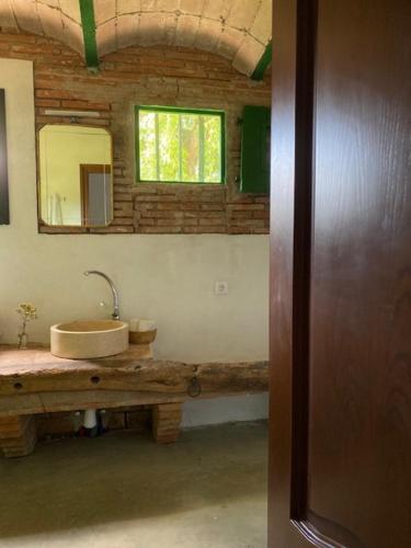 baño con lavabo y espejo en la pared en EL PALLER en Riudarenes