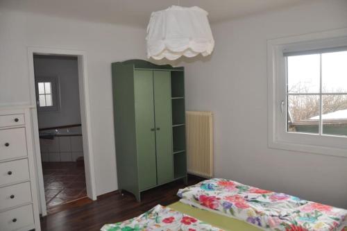 a bedroom with a green cabinet and a window at Ferienwohnung, wenige Minuten vom Wörthersee in Schiefling am See